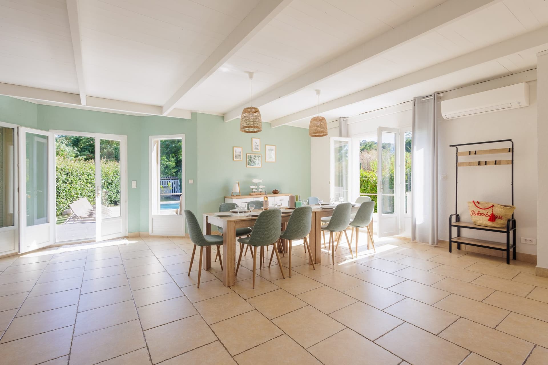 Salle à manger conviviale aux murs vert d’eau, accès direct au jardin